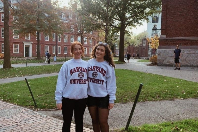 two female students standing at a landmark building